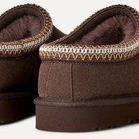 Pair of brown slippers with a textured sole on a light gray background
