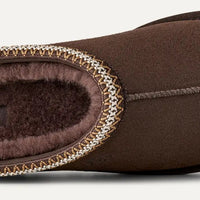 Brown UGG slipper on a light gray background
