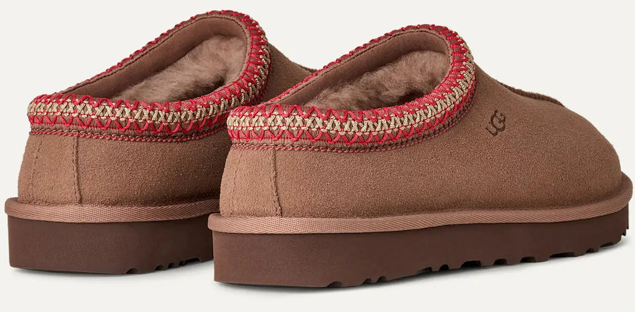 Brown slippers with red trim on a white background
