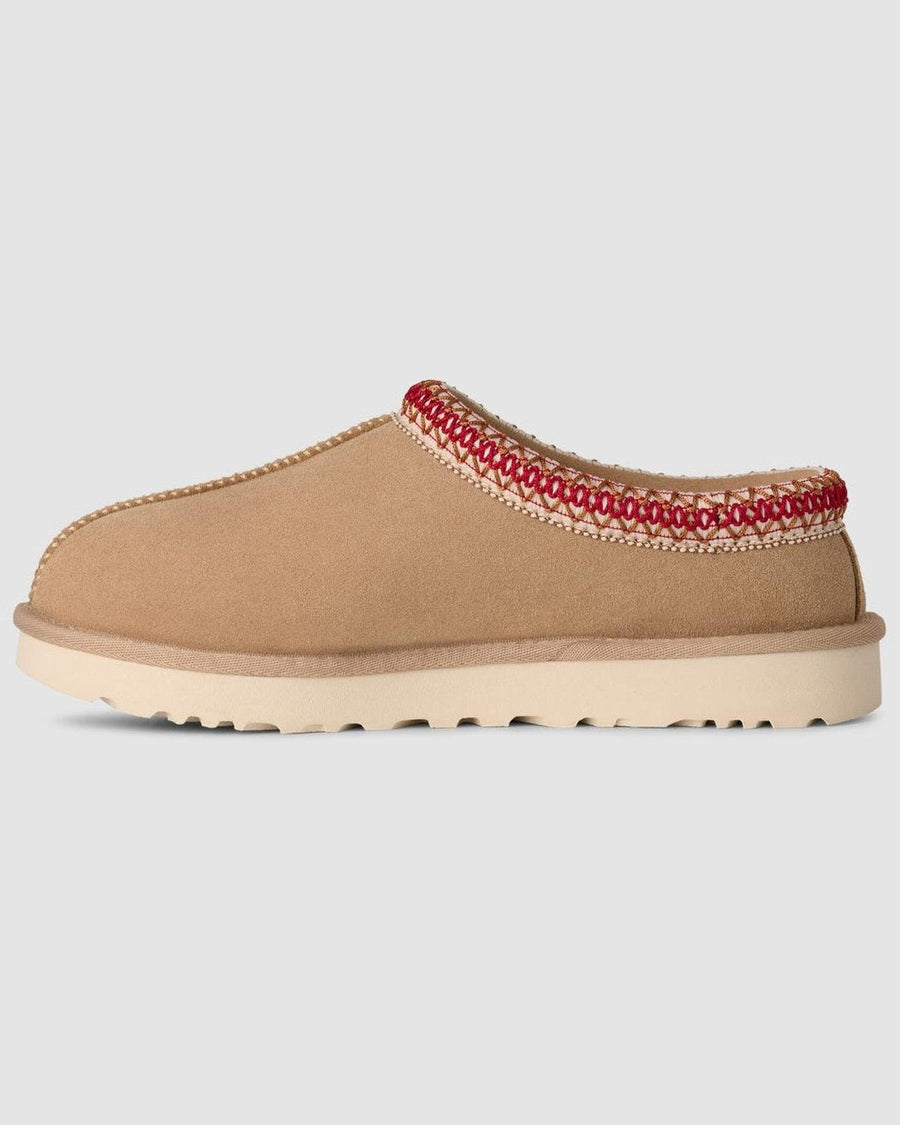 Tan slipper with red trim on a light gray background
