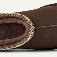 Brown UGG slipper on a light gray background