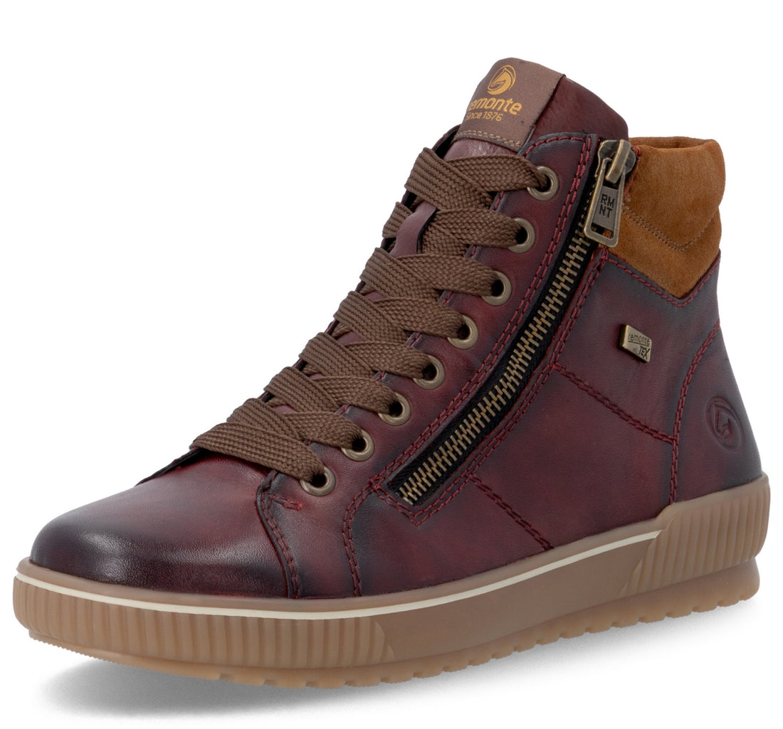 A mid-top leather sneaker boot in a deep burgundy red with brown laces, a brown suede ankle collar, and a tan gum sole, shown on a white background.