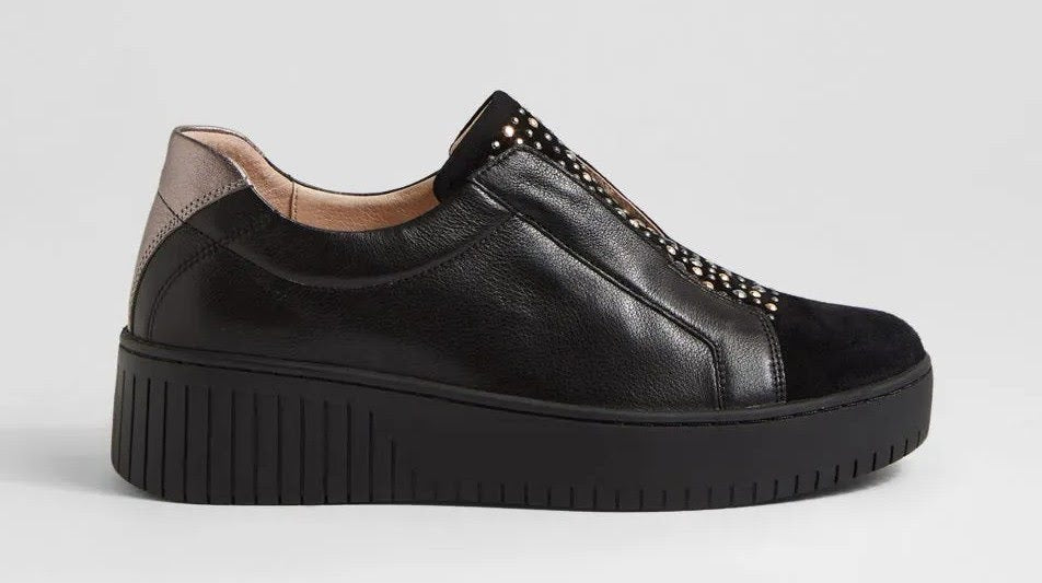 Black sneaker with platform sole on a light gray background